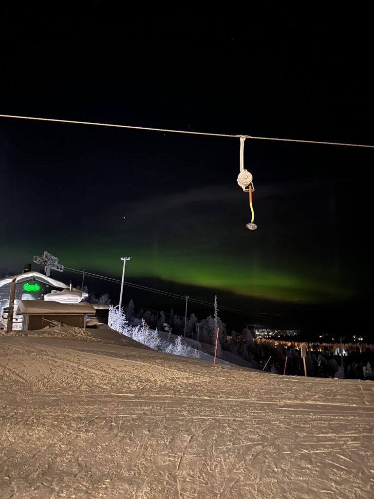 Schlepplift und Piste unter Polarlichtern