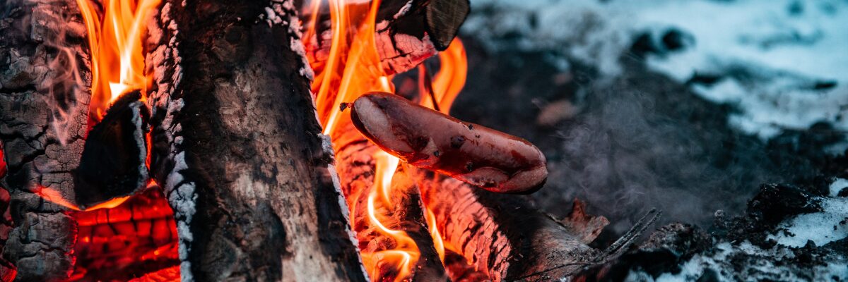 Rentierwurst über dem Lagerfeuer im Winter