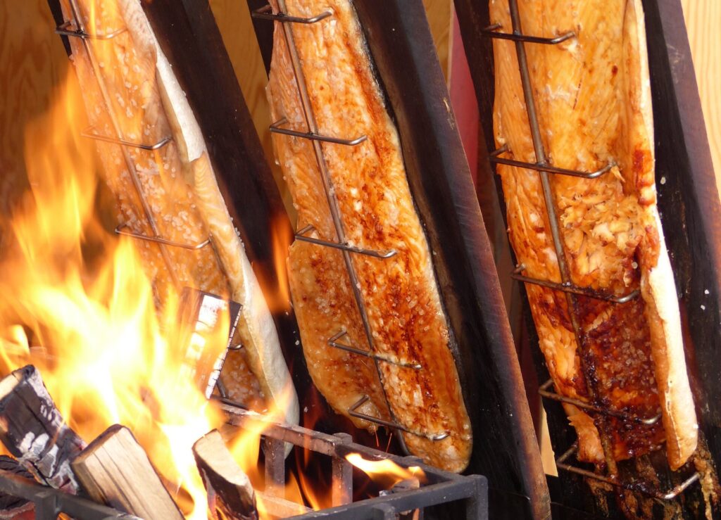 Flammlachs über loderndem Feuer