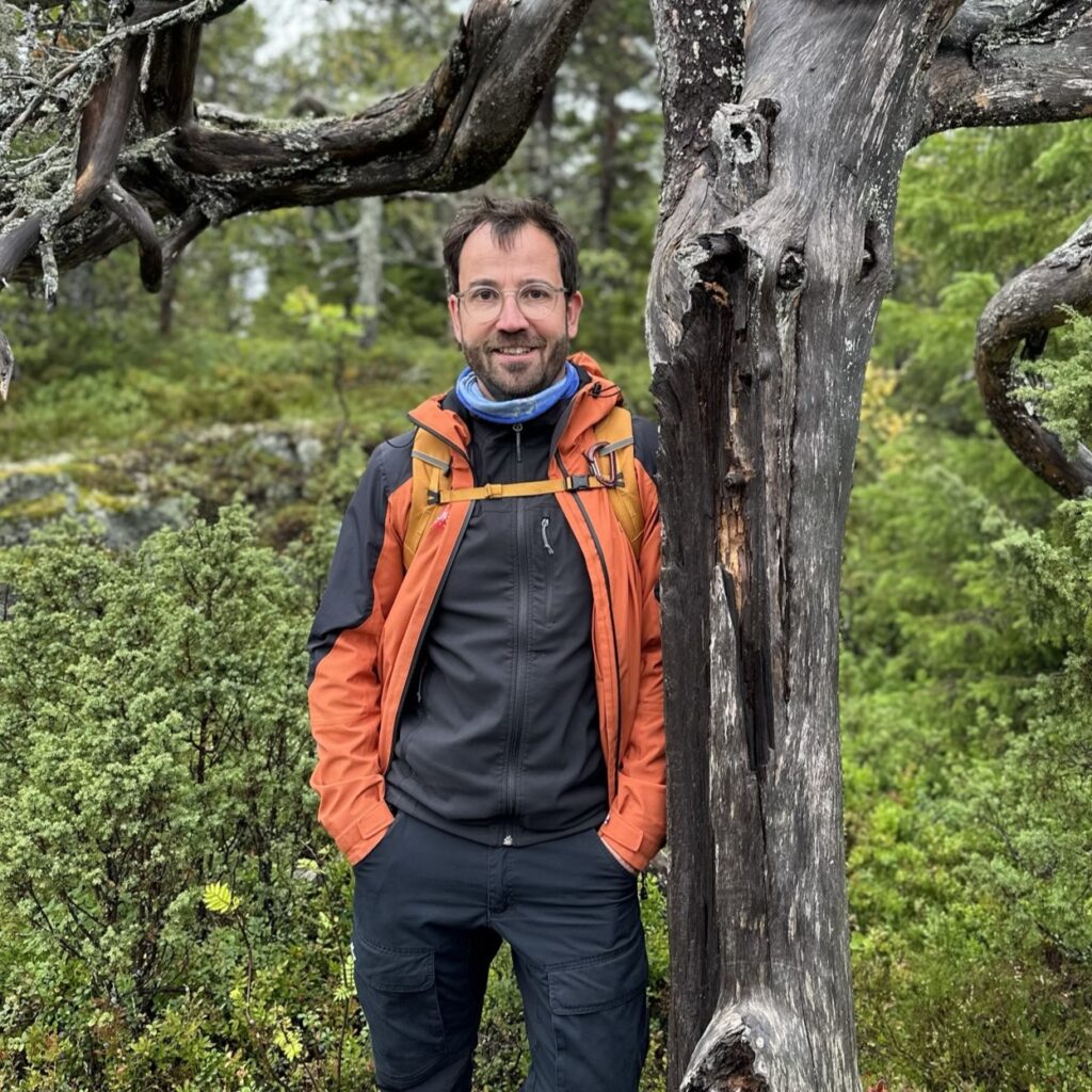 Thomas im Herbst in Finnland an Baum gelehnt